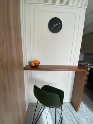 a desk with a chair and a clock on a wall at Studio moderne rooftop et gym Triangle d or casablanca in Casablanca
