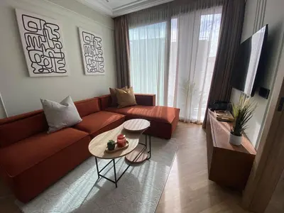 a living room with a couch and a table at Studio moderne rooftop et gym Triangle d or casablanca in Casablanca