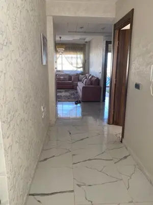a hallway with a tile floor and a living room at Jnane in Sidi Rahal