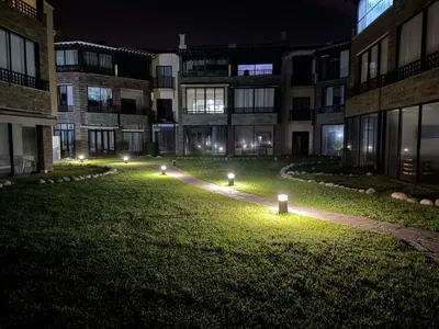 an empty courtyard at night with lights in the grass at Appartement à Dar bouaaza in Tamaris