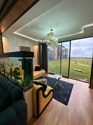 a living room with a large aquarium and a couch at Appartement à Dar bouaaza in Tamaris