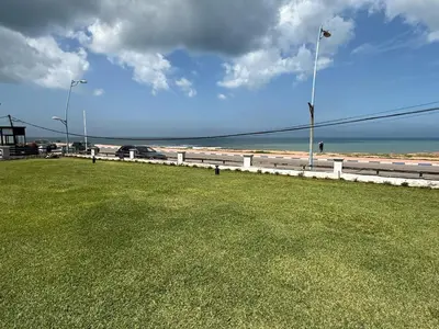 a grassy field next to a beach with a street light at Appartement à Dar bouaaza in Tamaris