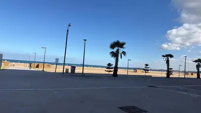 an empty parking lot next to a beach with palm trees at Appartement de lux avec piscine in Mohammedia