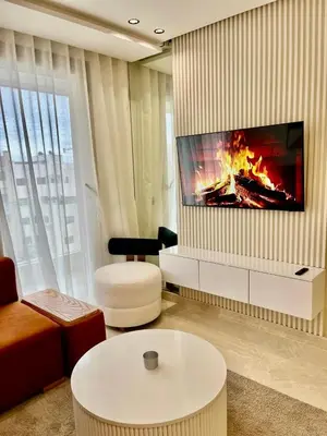 a living room with a fireplace and a tv at Bat infinity living in Casablanca