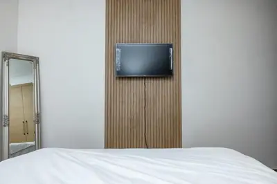 a bedroom with a tv on a wall next to a bed at Luxurious and comfortable in Prestigia in Rabat