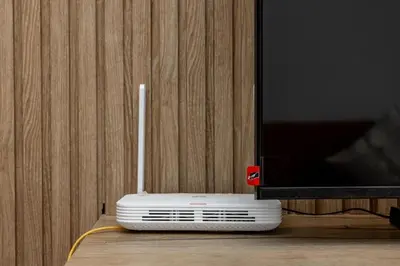 a white router sitting on a table next to a tv at Luxurious and comfortable in Prestigia in Rabat