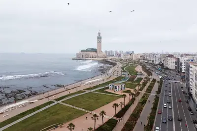 a city with a clock tower and the ocean at Corniche Guest idéal pour un séjour Inoubliable in Casablanca