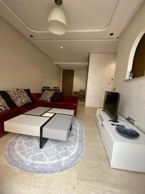 a living room with a red couch and a tv at Appt 1 ch meublé CFC TO CLOSE in Casablanca