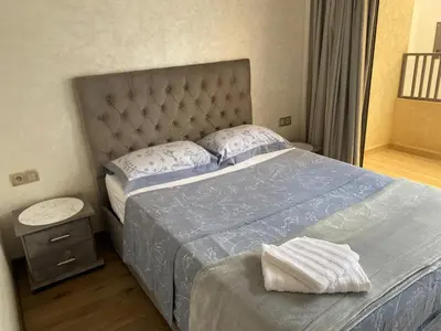 a bedroom with a bed with a blue comforter at Appt 1 ch meublé CFC TO CLOSE in Casablanca