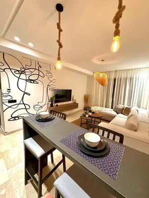 a living room with a table and a couch at Charming studio located in Tadart in Casablanca