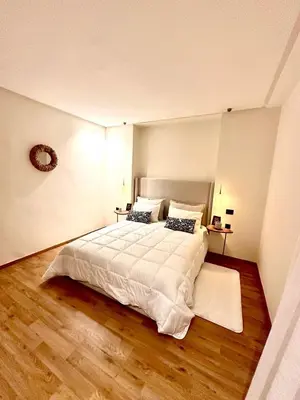 a bedroom with a large white bed and wooden floors at Charming studio located in Tadart in Casablanca
