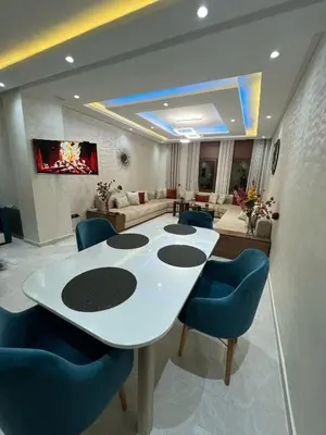a living room with a white table and blue chairs at Dar al bahr in Rabat