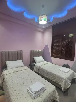 two beds in a room with a blue ceiling at Dar al bahr in Rabat