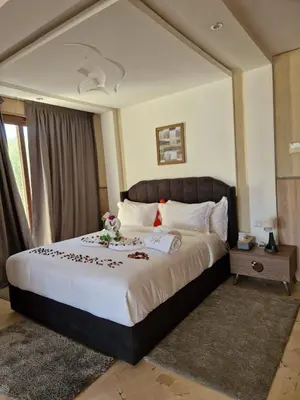 a bedroom with a large bed with flowers on it at Palm Palace Bouznika in Bouznika