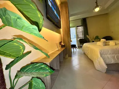 a bedroom with a bed and a large green plant at cosy studio au cœur de rabat agdal in Rabat