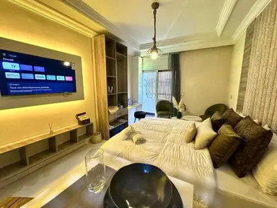 a bedroom with two beds and a flat screen tv at cosy studio au cœur de rabat agdal in Rabat