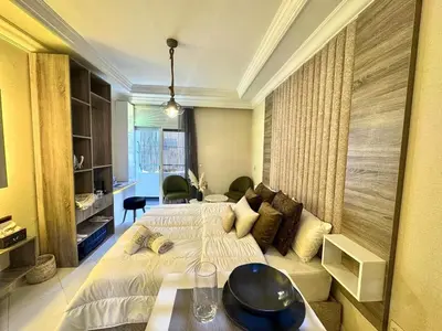 a hotel room with two beds and a couch at cosy studio au cœur de rabat agdal in Rabat