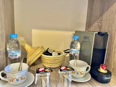 a table with cups and bottles of water and other items at cosy studio au cœur de rabat agdal in Rabat