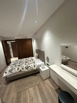 a bedroom with a large bed and a mirror at Résidence Signature Leving in Maarif