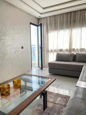 a living room with a glass table and a couch at Appartement in Casablanca