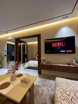 a living room with a television on the wall at Deux studios luxueux à palmiers Casablanca in Casablanca