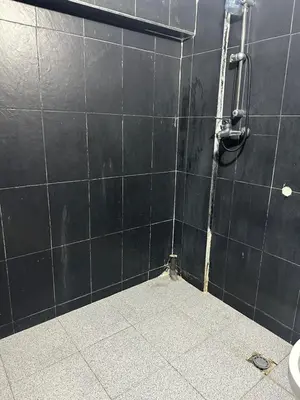 a bathroom with a black tiled wall with a shower at Maison in Mohammedia