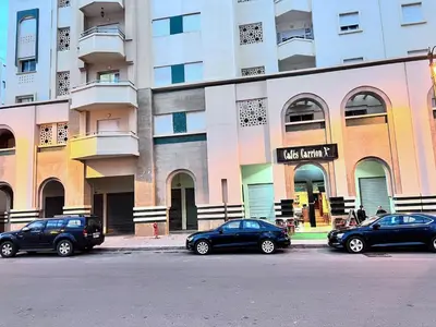 three cars parked in a parking lot in front of a building at Beachfront apartment in Rabat