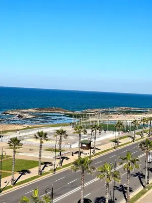 an empty street with palm trees and the ocean at Ocean view & sunset in the heart of Rabat 2 in Rabat
