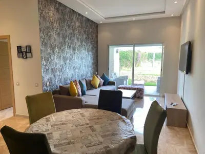 a living room with a couch and a table at CASABAY Sidi Rahal, appartement avec accès direct à la piscine in Sidi Rahal