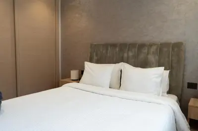 a bedroom with a large bed with white sheets and pillows at Prime location unmatched comfort in Casablanca