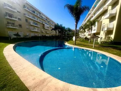 a large blue swimming pool in front of a building at Les Jardins de Bouznika Premium - Votre espace familial in Bouznika