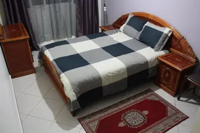 a bedroom with a bed and a table and a rug at Bienvenue à Casablanca centre idéal pro ou famille in Casablanca