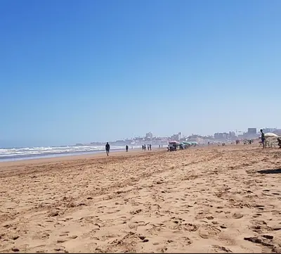 a group of people walking on the beach at Bienvenue à Casablanca centre idéal pro ou famille in Casablanca