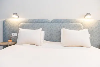 a bed with two white pillows and a blue headboard at Cozy apartment 5 minutes from Casa Voyageurs in Casablanca