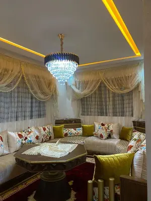 a living room with a couch and a chandelier at Appartement meublé a sidi rahal in Sidi Rahal
