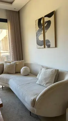 a white couch in a living room with a painting at Modern and cozy accommodation in Rabat in Rabat