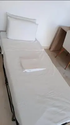 a bed with white sheets and pillows in a room at Modern and cozy accommodation in Rabat in Rabat