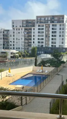 a swimming pool in front of a large building at Modern and cozy accommodation in Rabat in Rabat