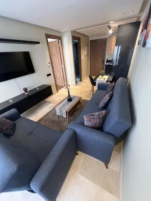 a living room with a blue couch and a tv at Great for families and couples in Casablanca