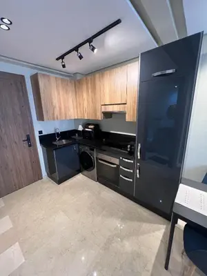 a kitchen with black appliances and wooden cabinets at Great for families and couples in Casablanca