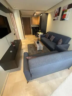 a living room with a blue couch and a table at Great for families and couples in Casablanca
