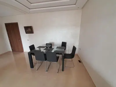 a dining room with a table and black chairs at Le passage inoubliable in Bouznika
