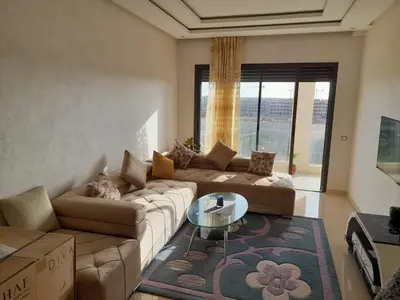a living room with a couch and a glass table at Le passage inoubliable in Bouznika