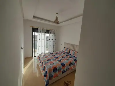 a bedroom with a bed and a large window at Le passage inoubliable in Bouznika