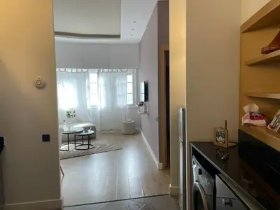 a kitchen with a hallway with a table and a refrigerator at appartement Gautier in Casablanca