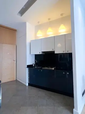 a kitchen with white cabinets and a black counter top at appartement Gautier in Casablanca