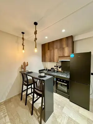 a kitchen with a black refrigerator and a table with chairs at Beautiful apartment in Tadart in Casablanca