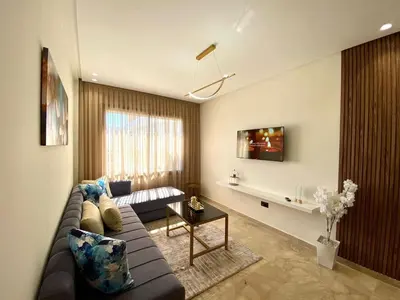a living room with a couch and a table at Très beau appartement a tadart au centre de casablanca in Casablanca