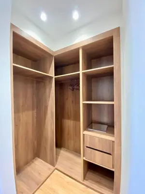 a walk in closet with wooden shelves at Très beau appartement a tadart au centre de casablanca in Casablanca