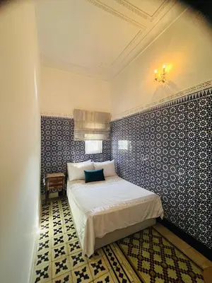 a bedroom with a bed with blue and white tiles at Maison traditionnelle spacieuse in Rabat